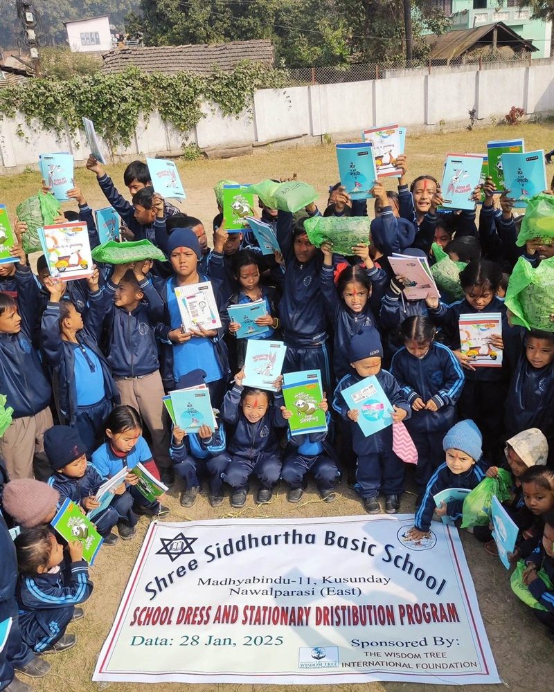 A schoolyard full of students in navy uniforms holding exercise books above their heads